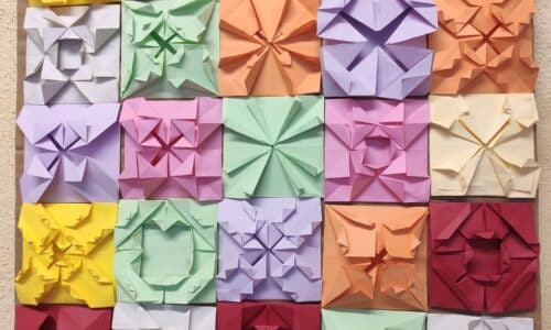 Mosaicos de papiroflexia de colores colocados sobre una mesa, una propuesta para explorar geometría, patrones y matemáticas de verano sin fichas.